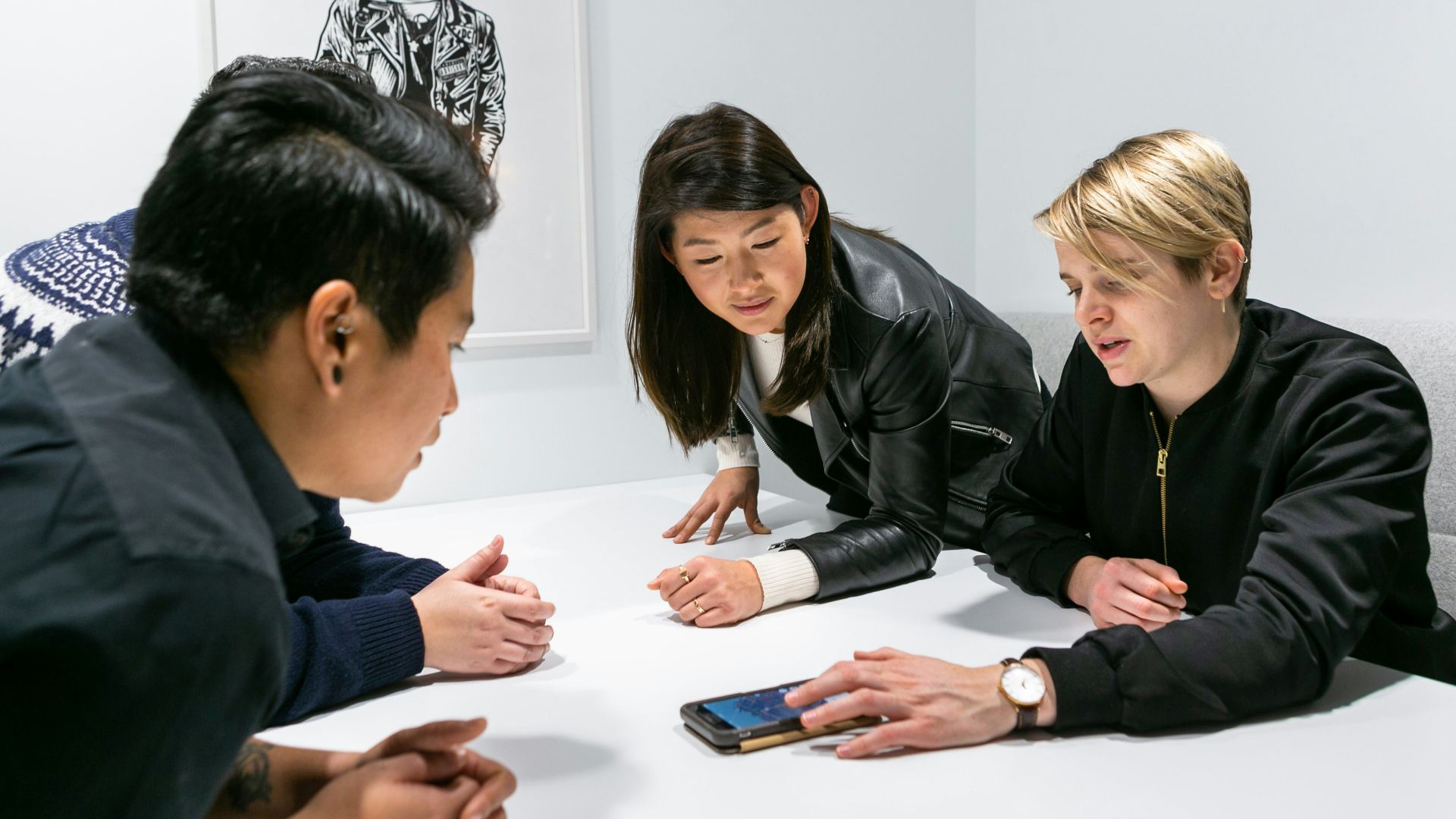 people in a meeting in a white room discussing app development