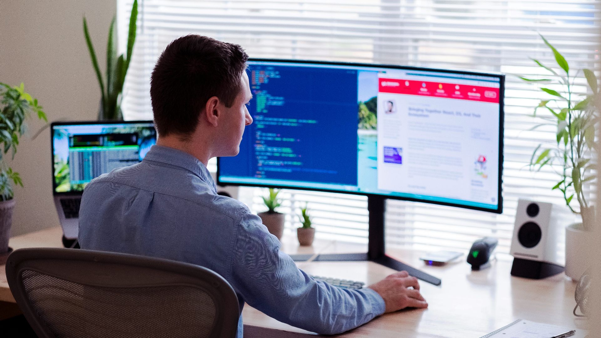 man in gray dress shirt sitting on chair in front of computer monitor