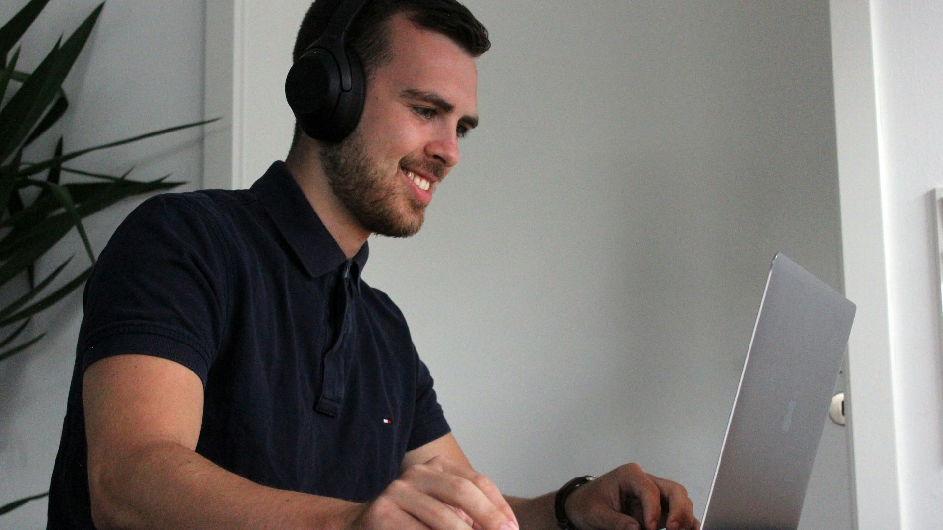man in black polo shirt using laptop computer