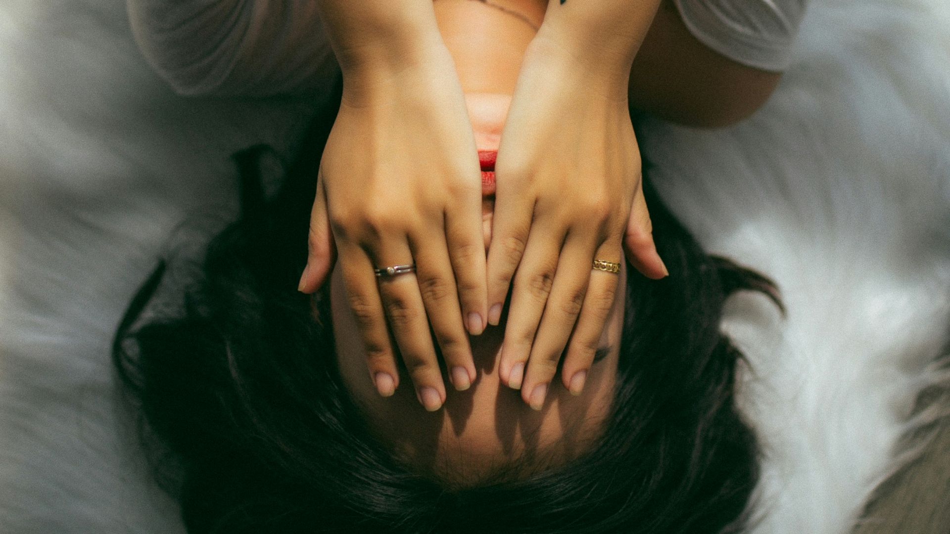 a woman holds her hands over her face