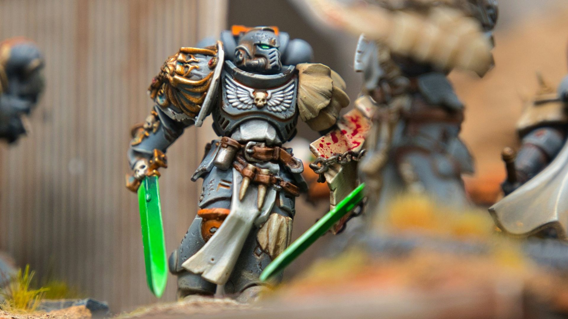 A group of warhammers on a table with a building in the background