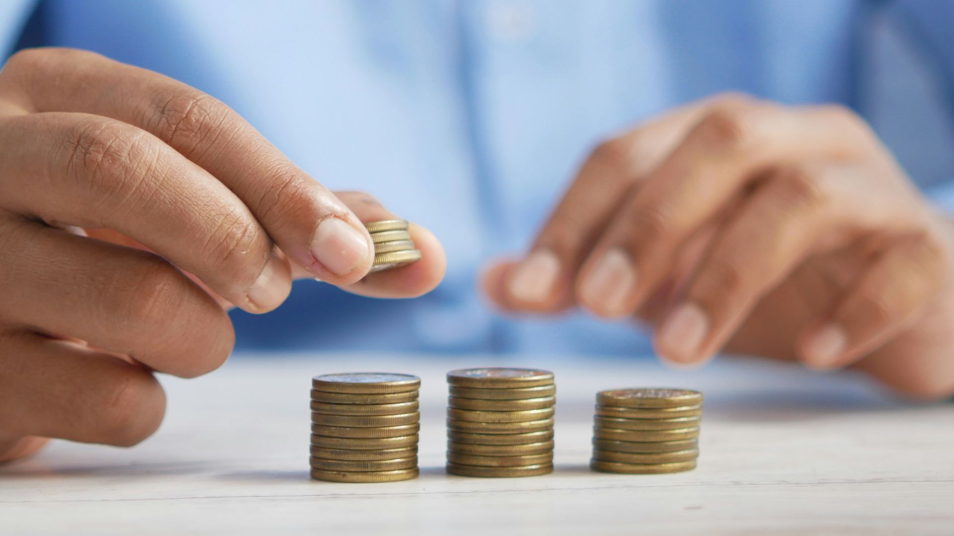 a person stacking coins on top of a table