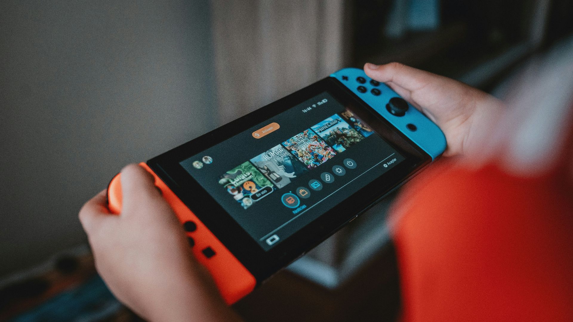 person holding black and orange nintendo switch