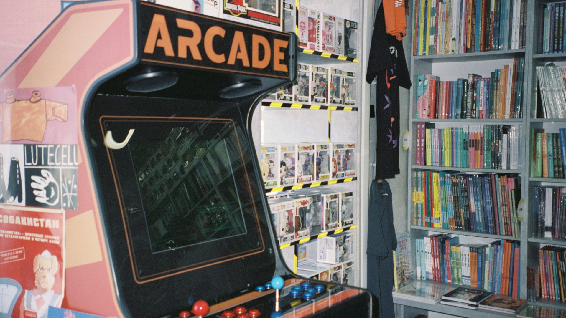An arcade machine in front of a bookshelf