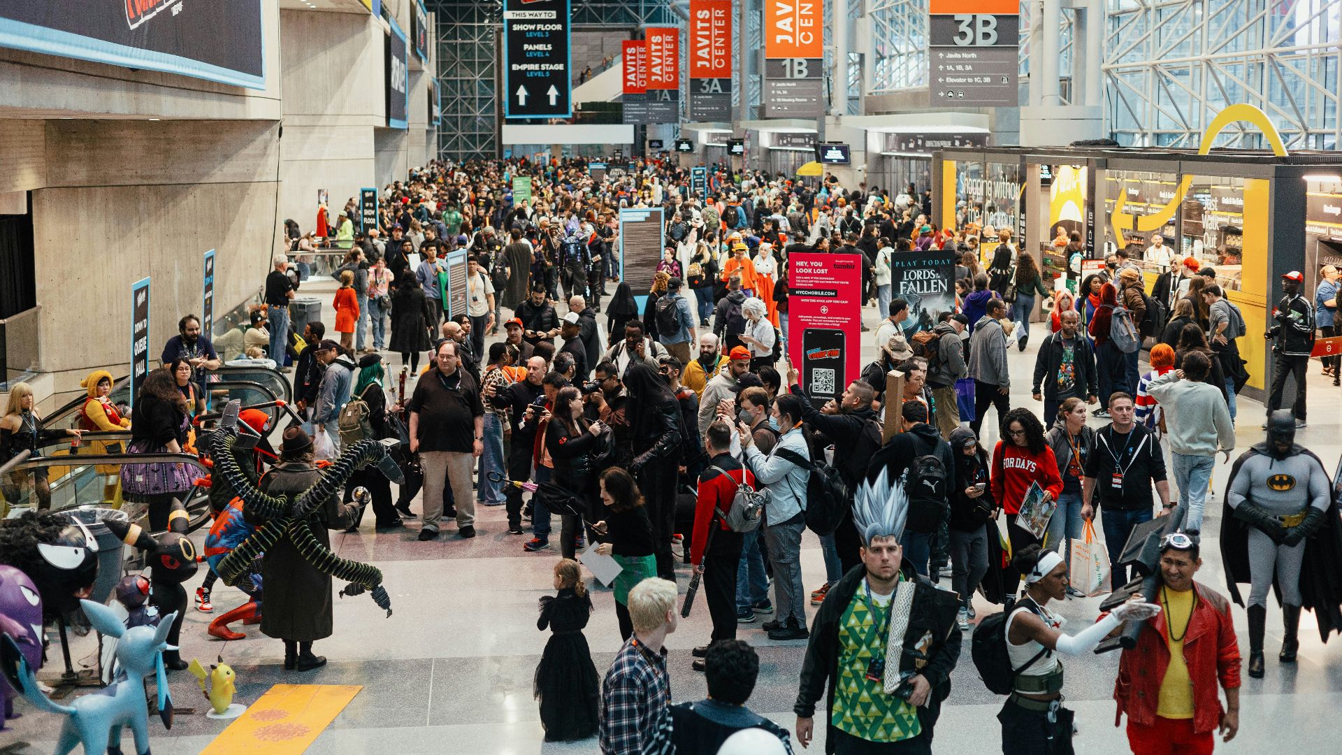 a large group of people walking through an airport