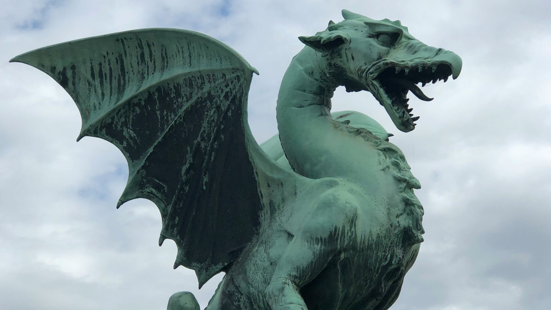 a statue of a green dragon on a pedestal