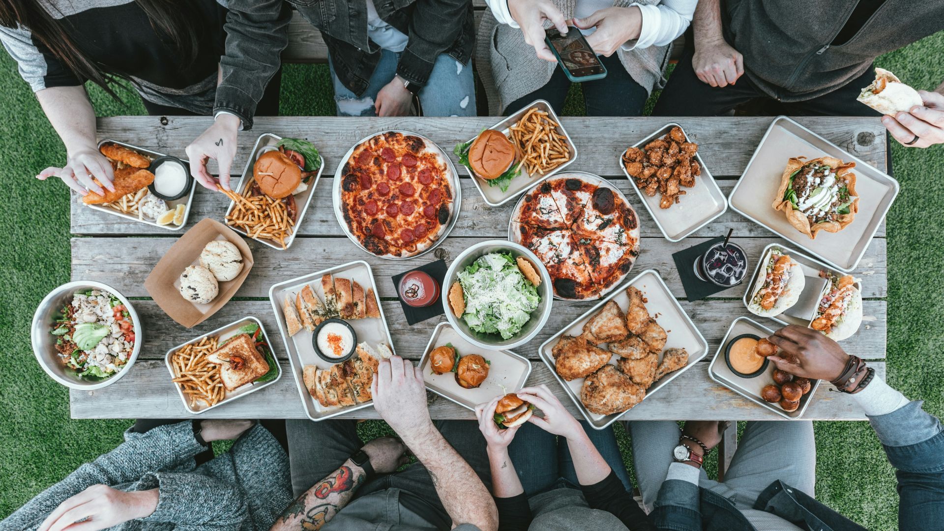 a group of people sitting around a table with food
