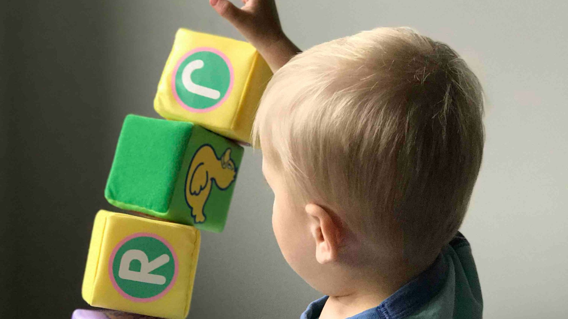 boy playing cube on white wooden table