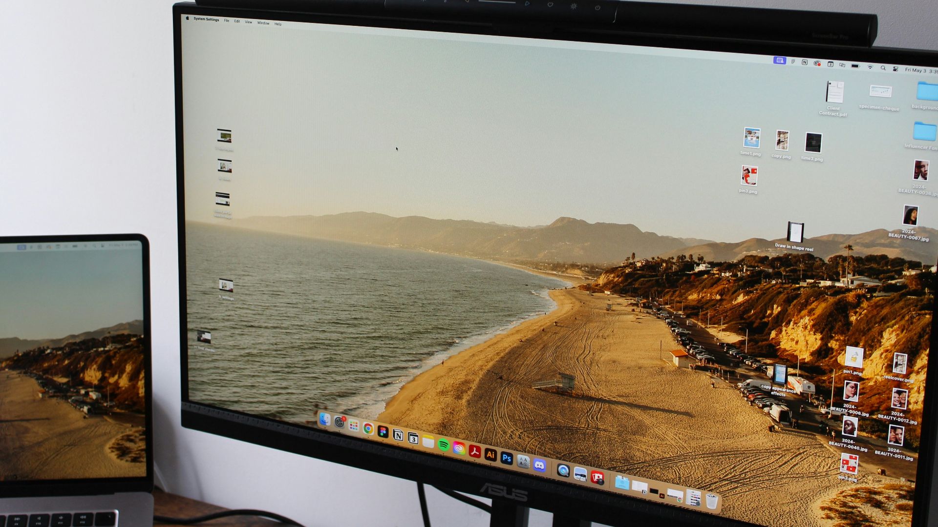 a laptop computer sitting on top of a desk next to a monitor