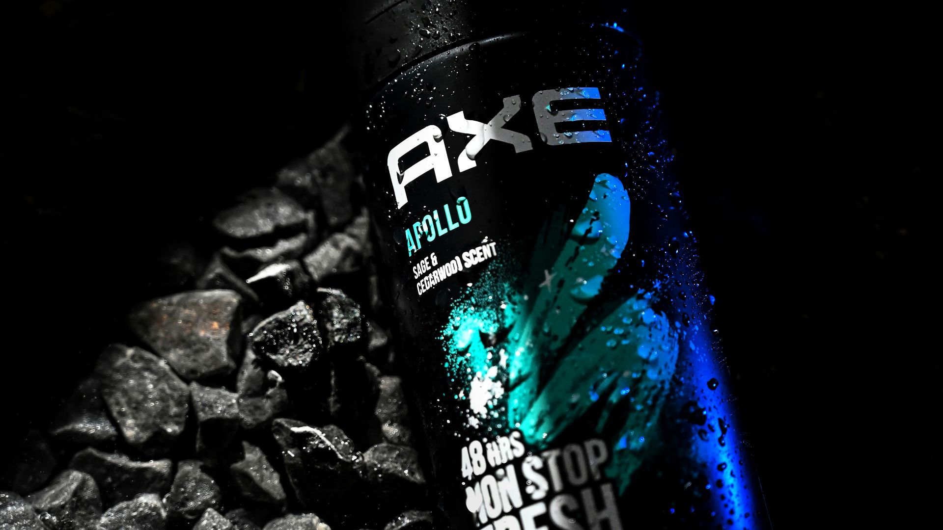 a close up of a bottle of water on a bed of rocks