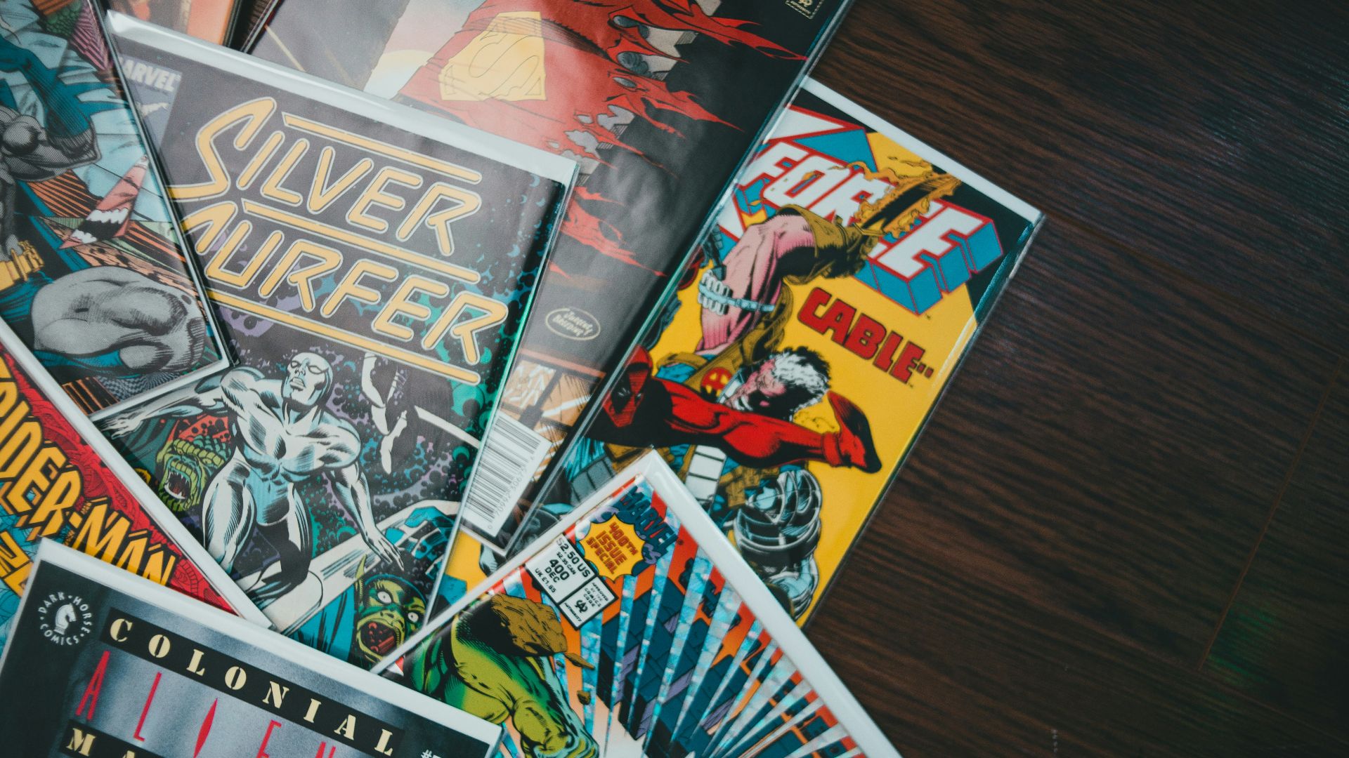 a pile of comics sitting on top of a wooden table