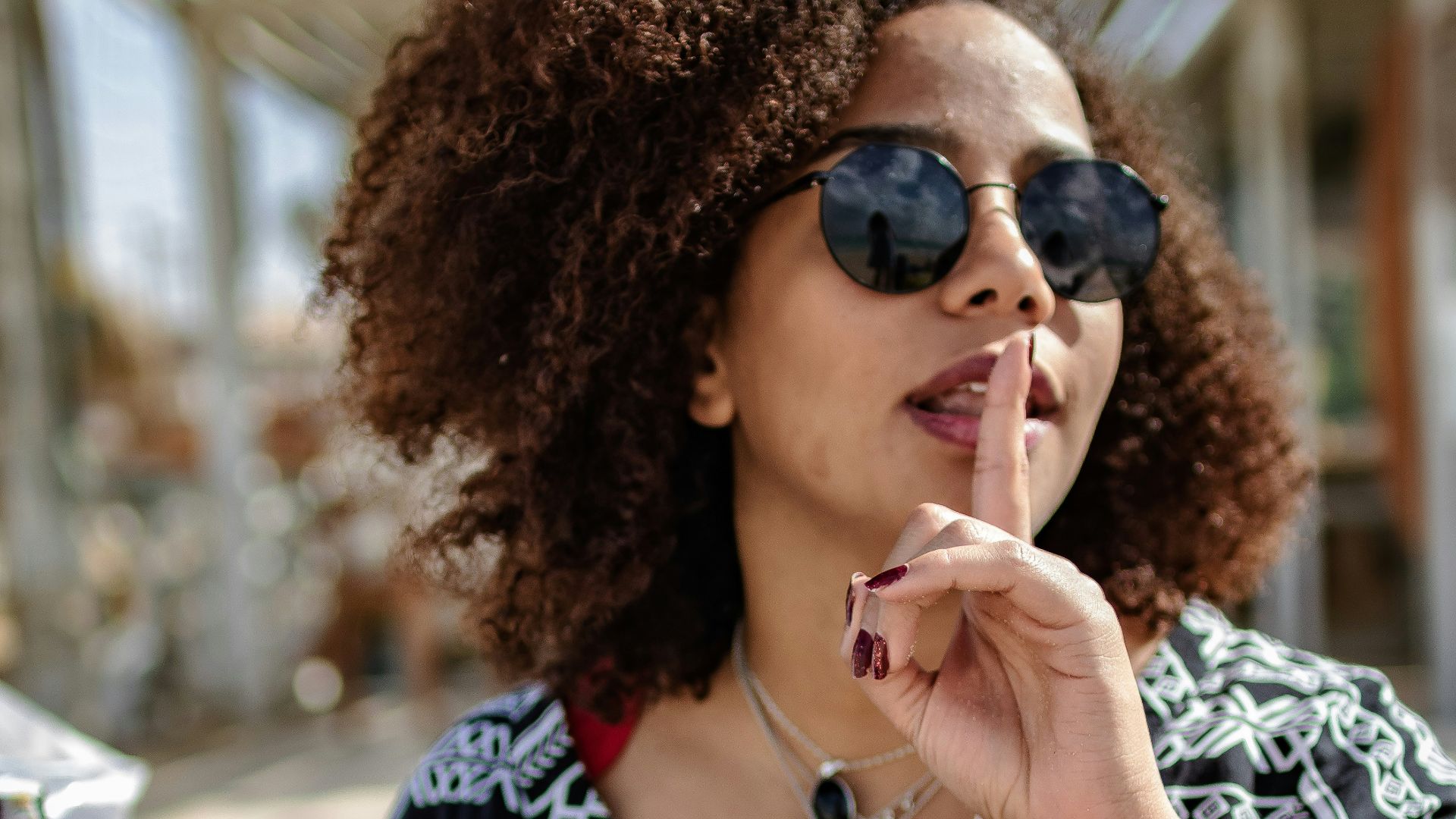 a woman wearing sunglasses and smoking a cigarette