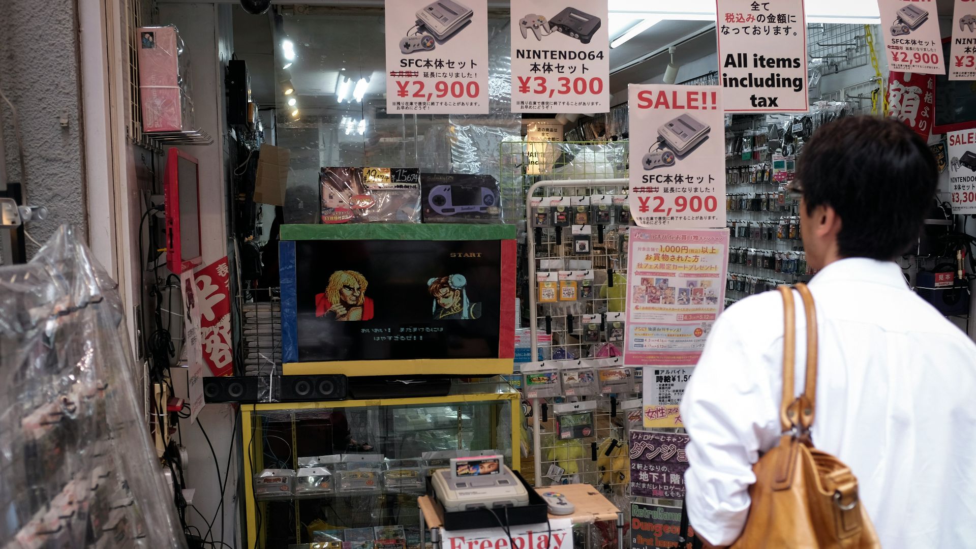 man in white dress shirt and brown pants standing near glass shelf
