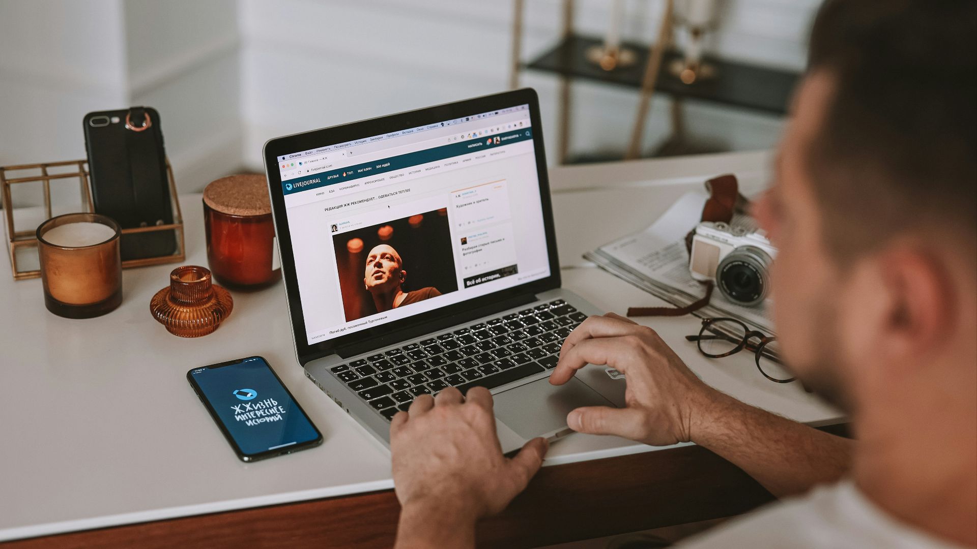 a man sitting at a desk using a laptop computer