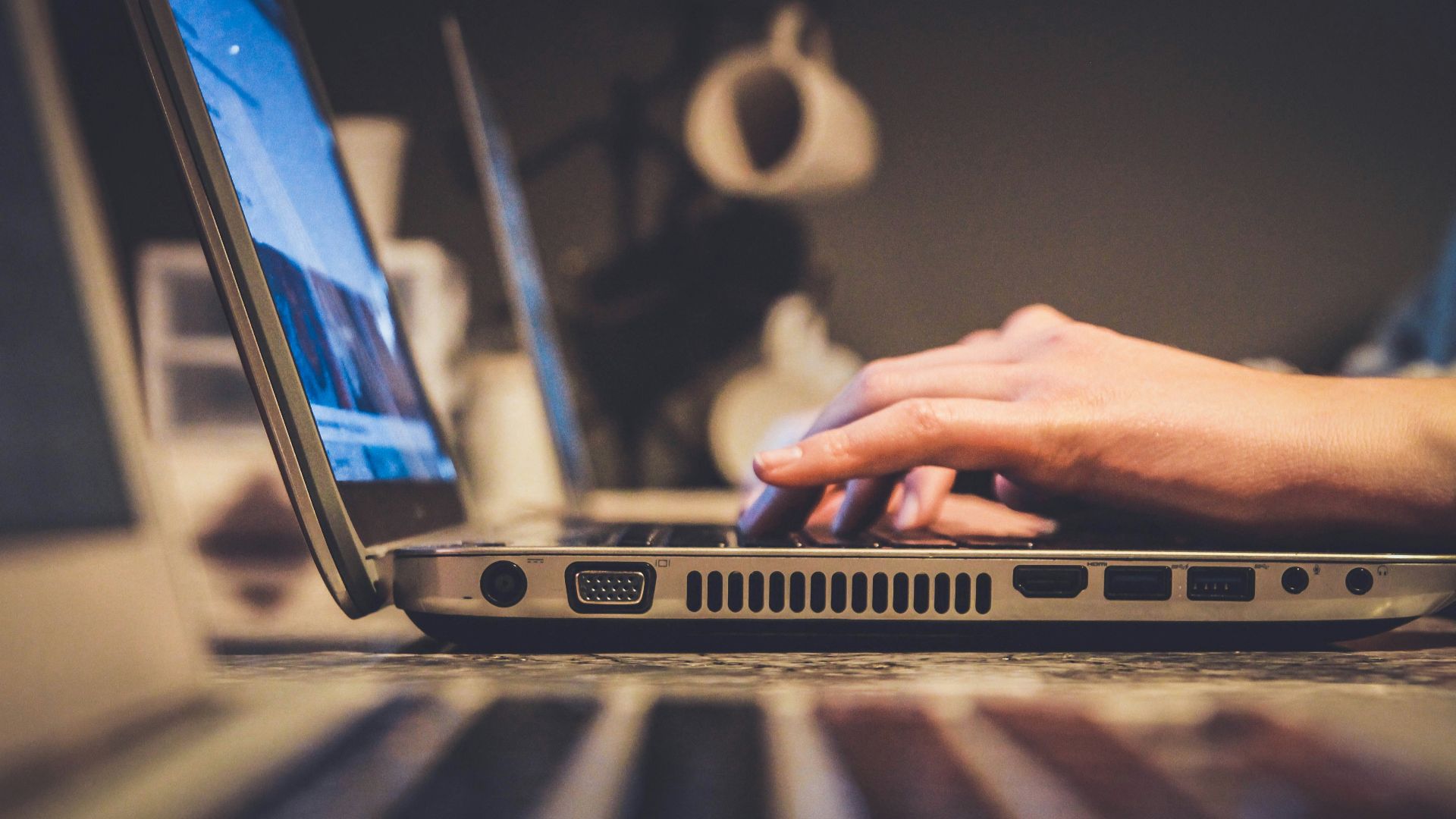 person using silver laptop computer on desk
