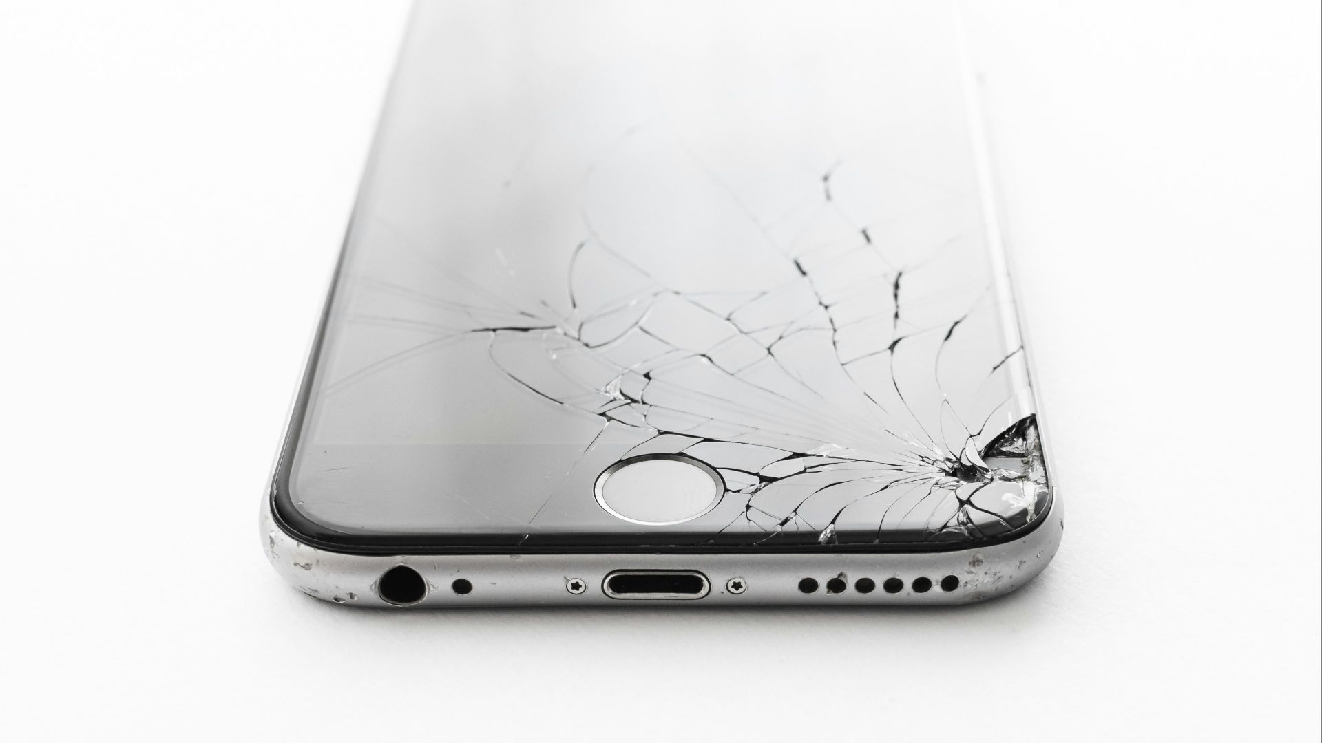 a broken cell phone sitting on top of a white table