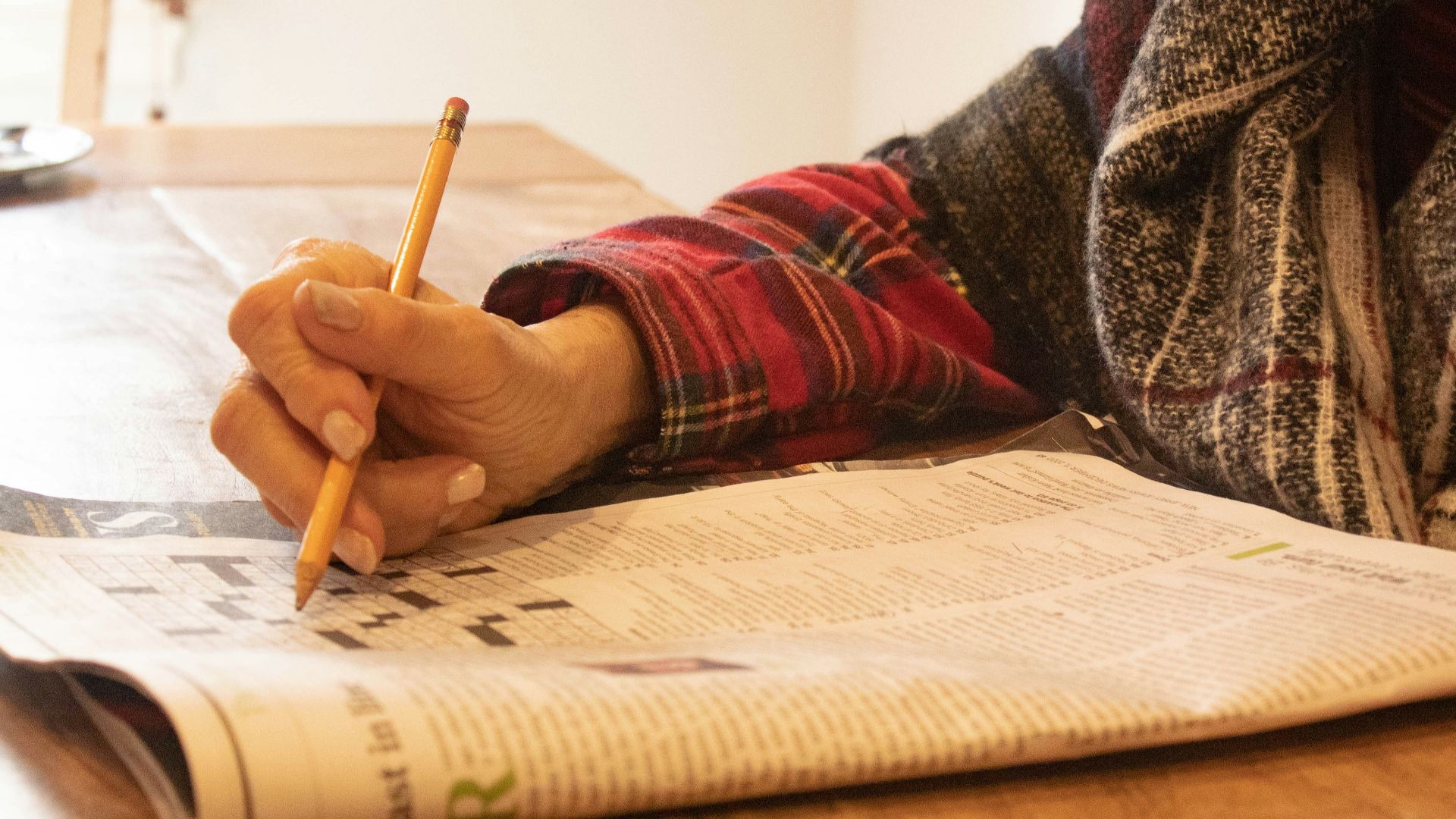 person in black and white sweater writing on white paper
