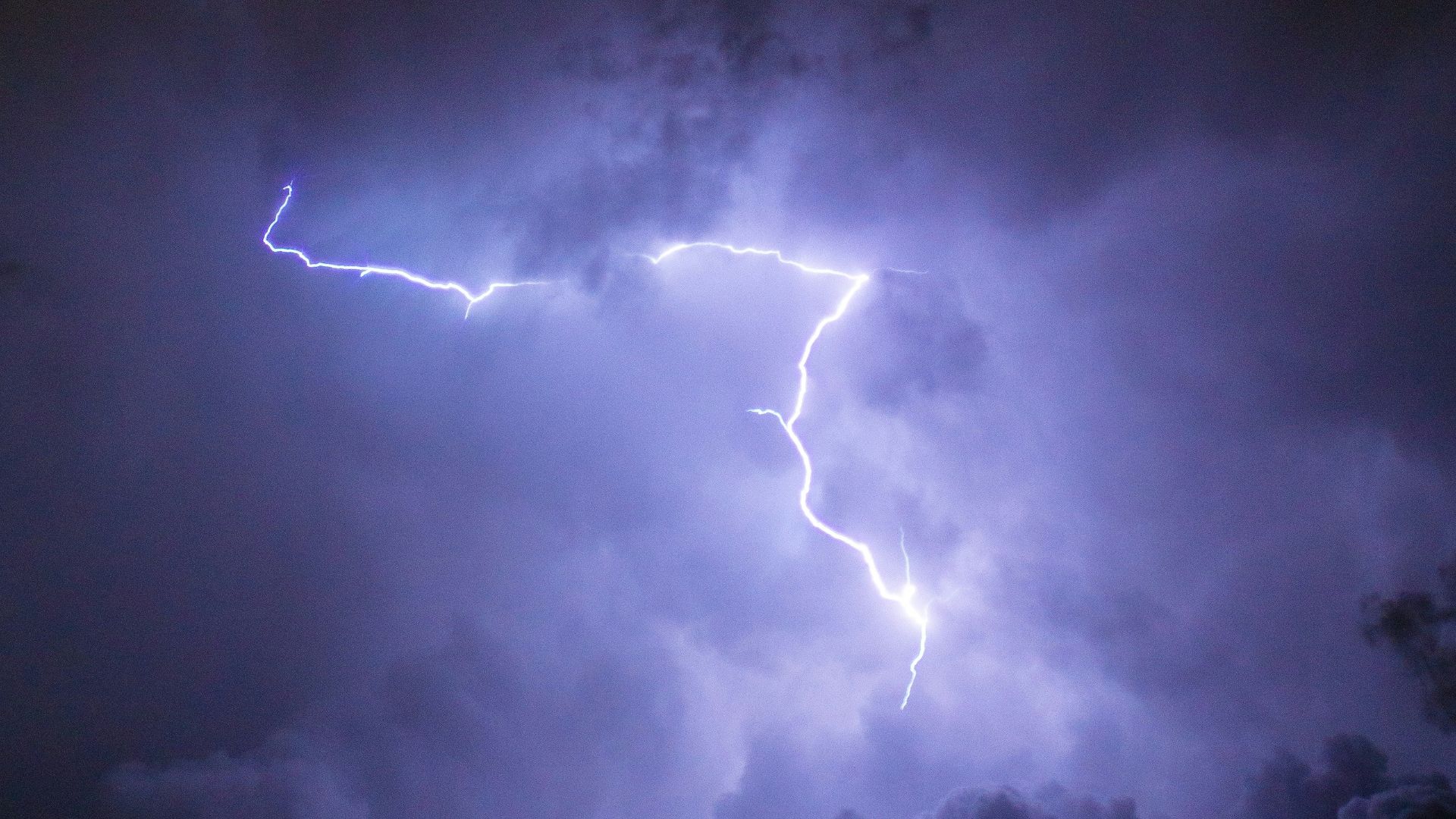 a lightning bolt hitting through a cloudy sky