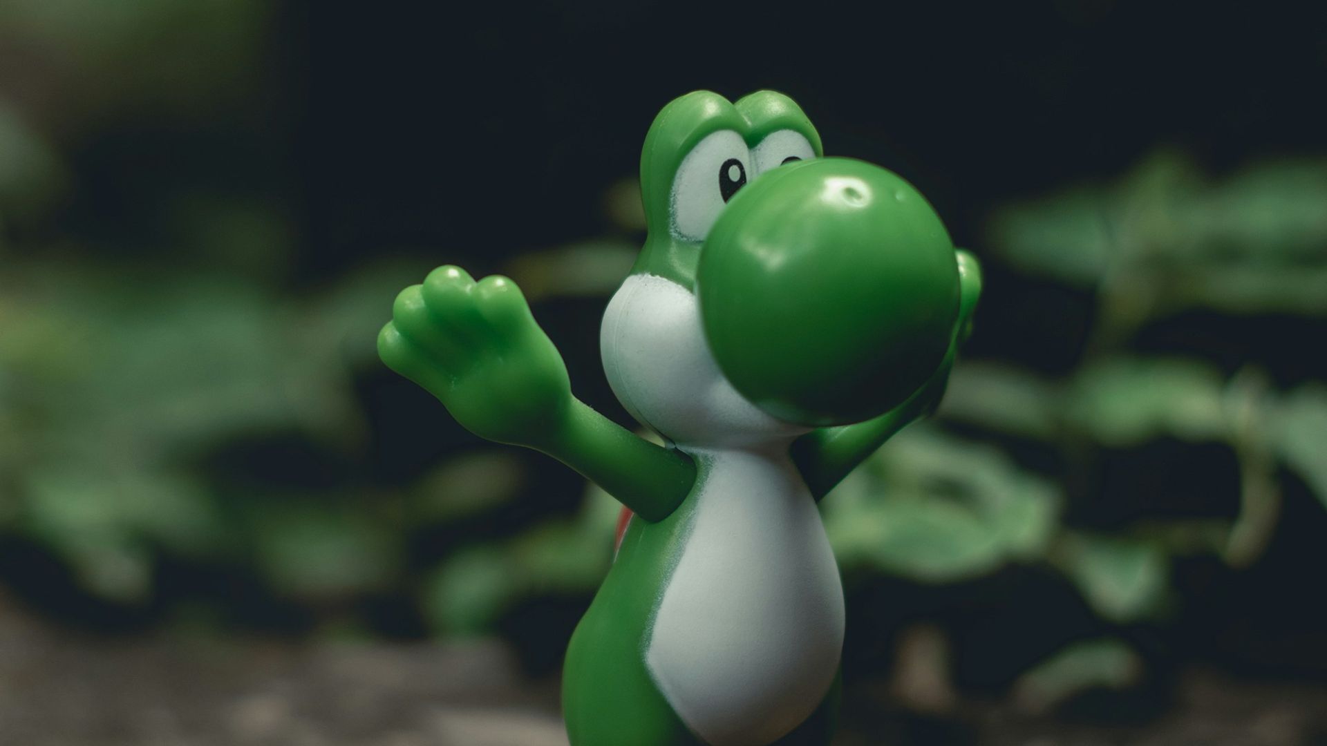 green frog figurine on black and brown surface