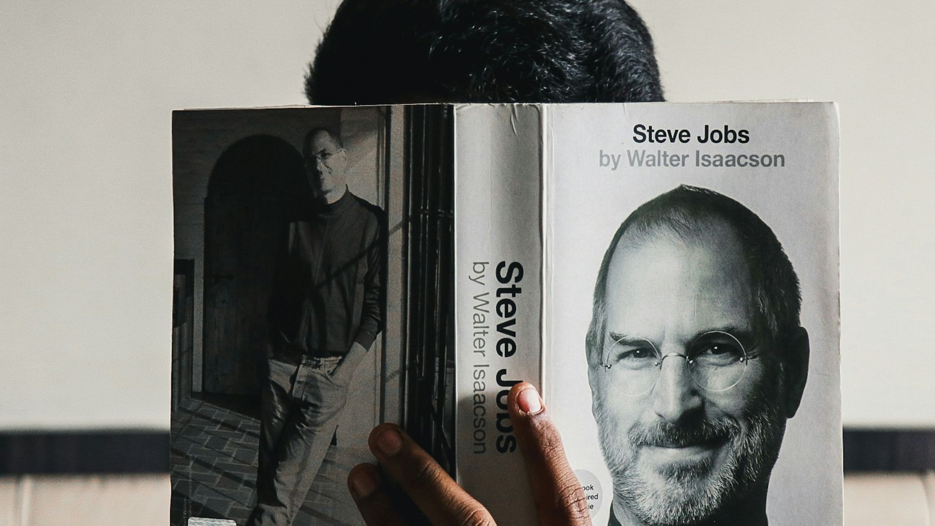 man in black crew neck shirt holding white printer paper