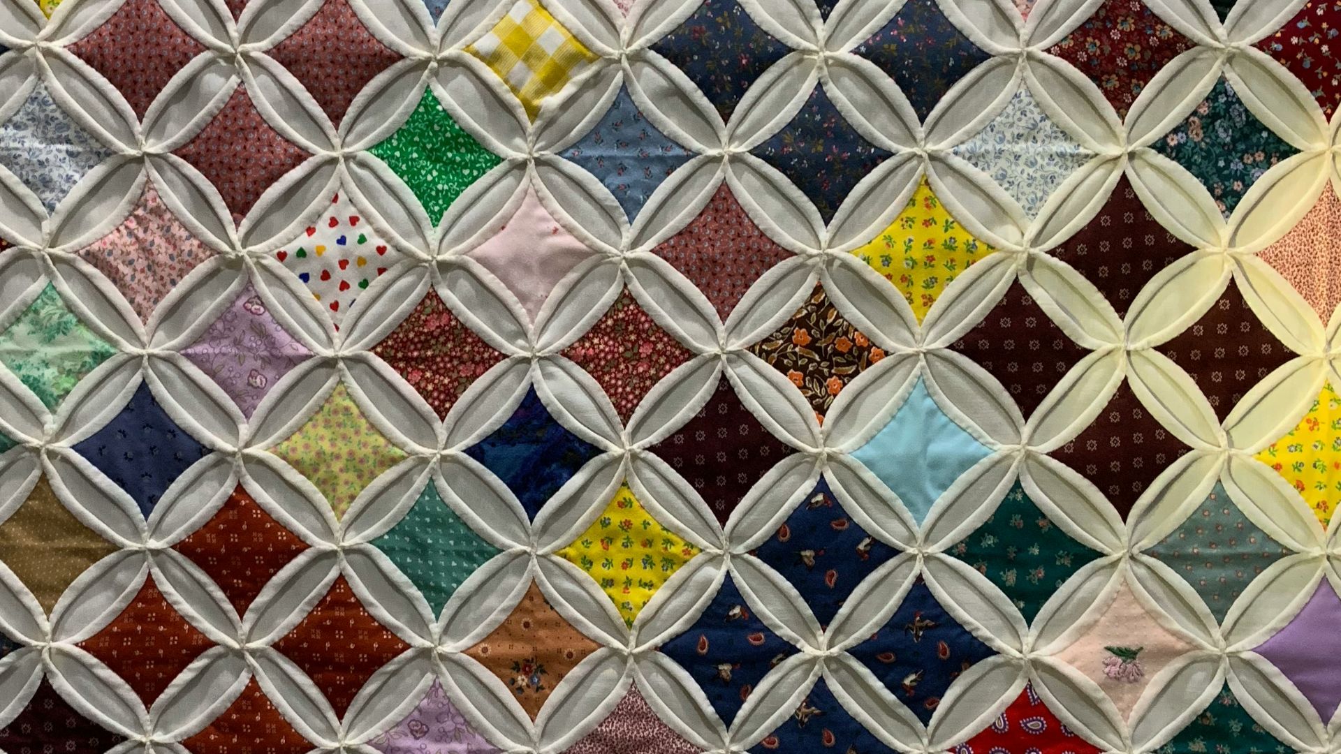 a close up of a quilt with many different colors