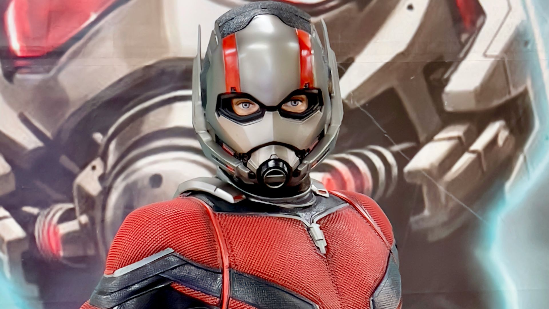 a man in a red and black suit standing next to a giant robot