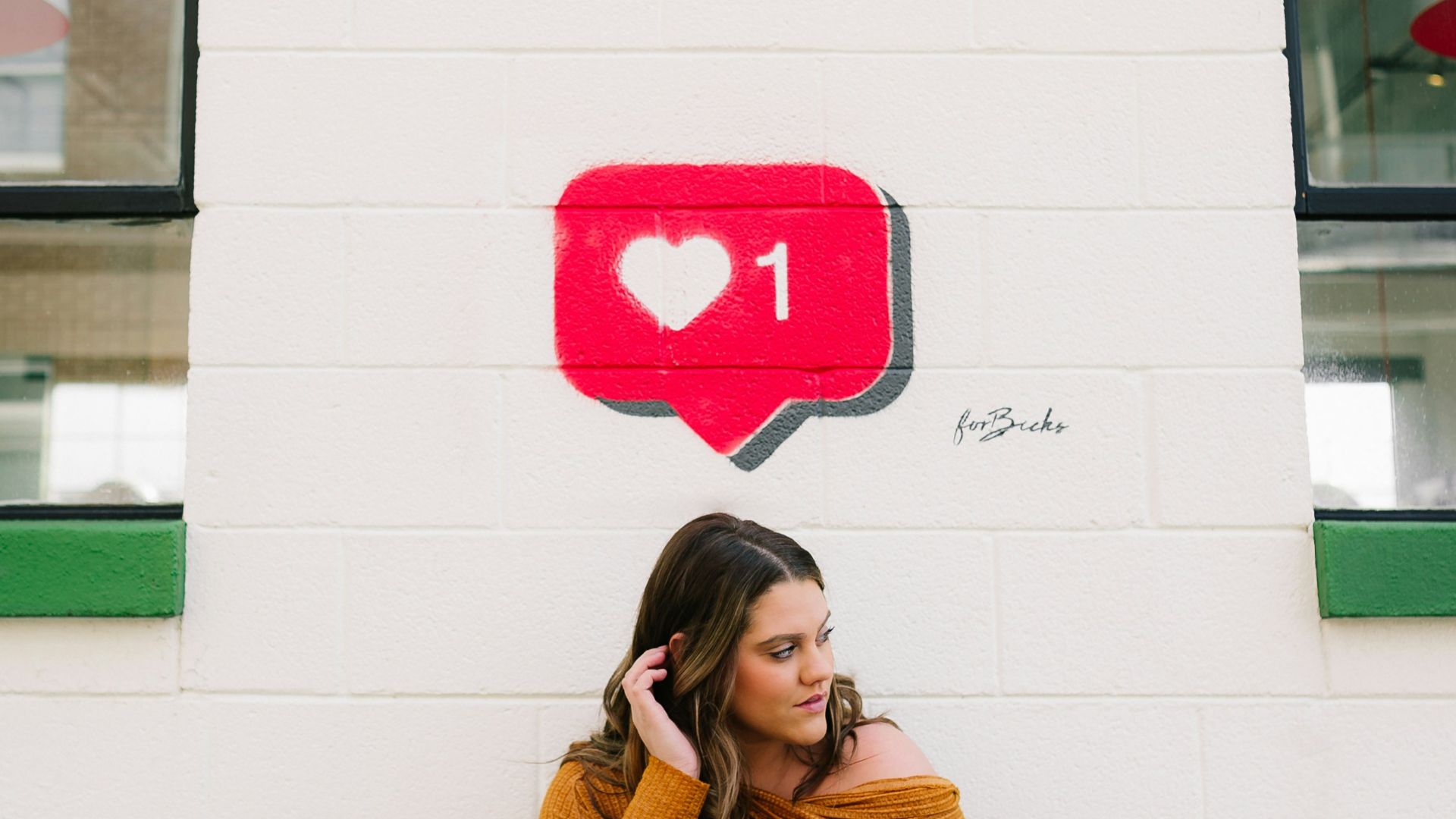 woman in brown turtleneck sweater covering her face with her hand