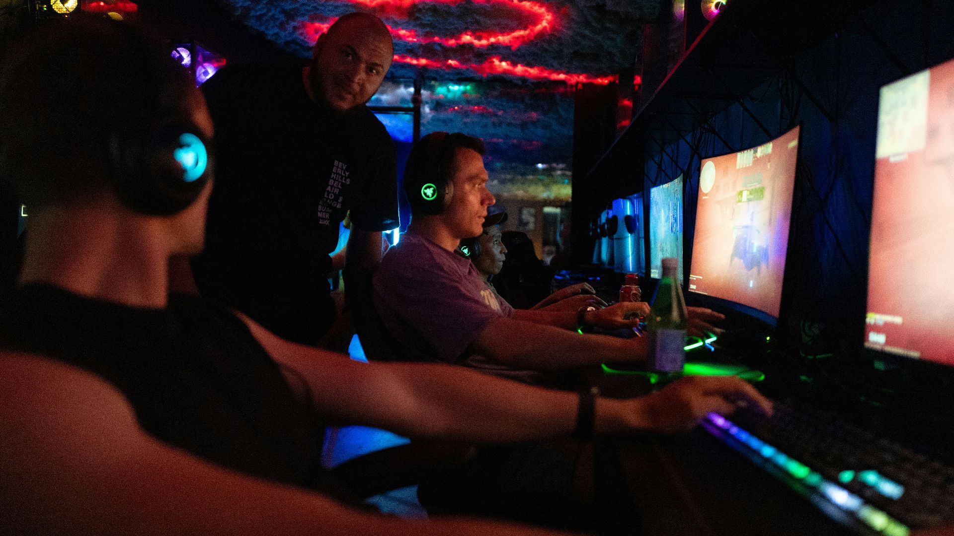 People playing video games in a dimly lit room.