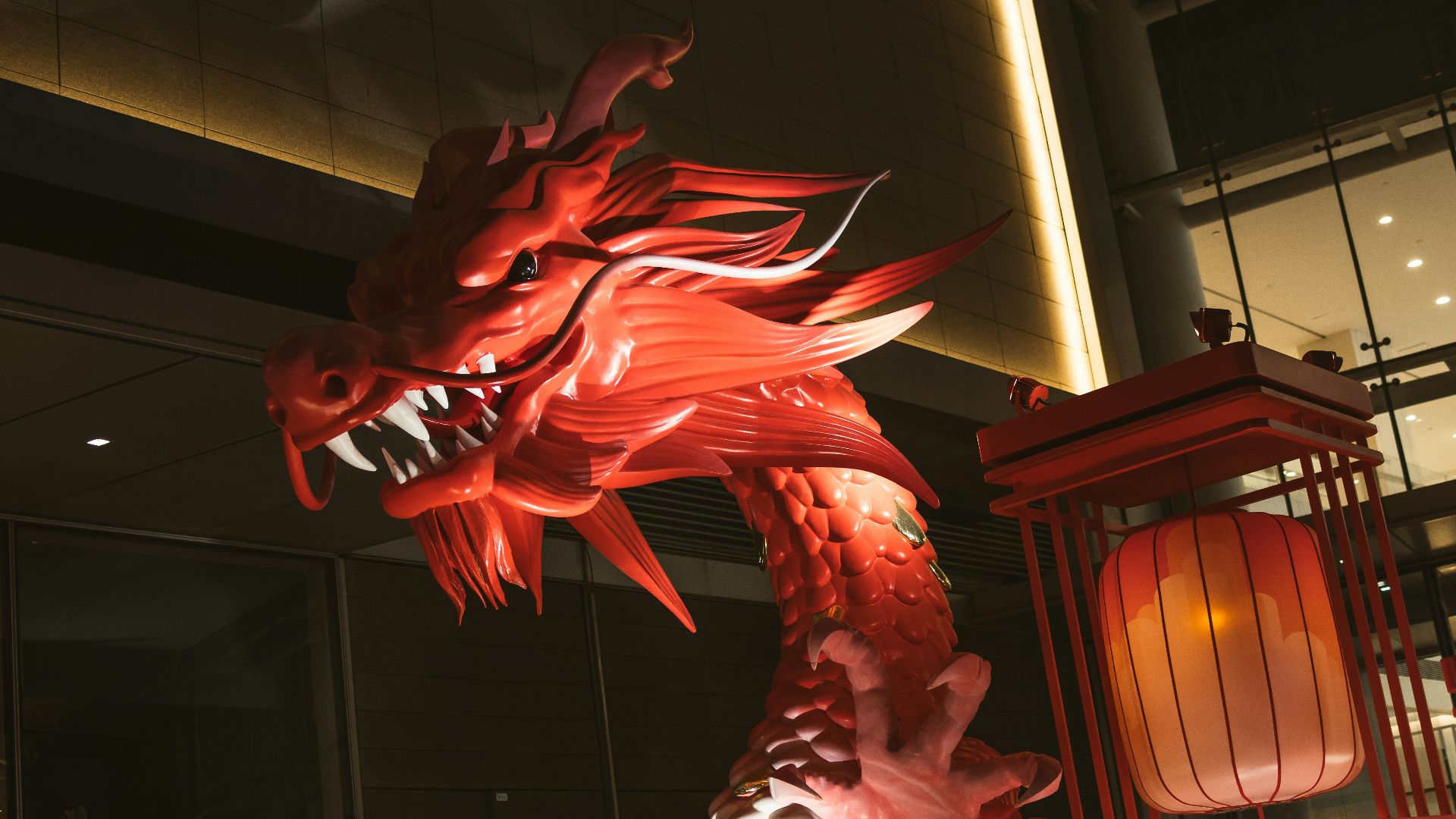 a large red dragon statue next to a lantern