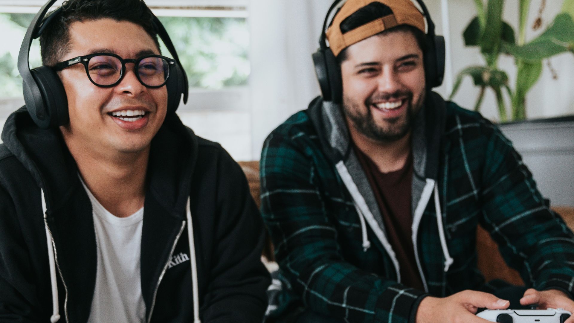 a couple of men sitting at a table with game controllers