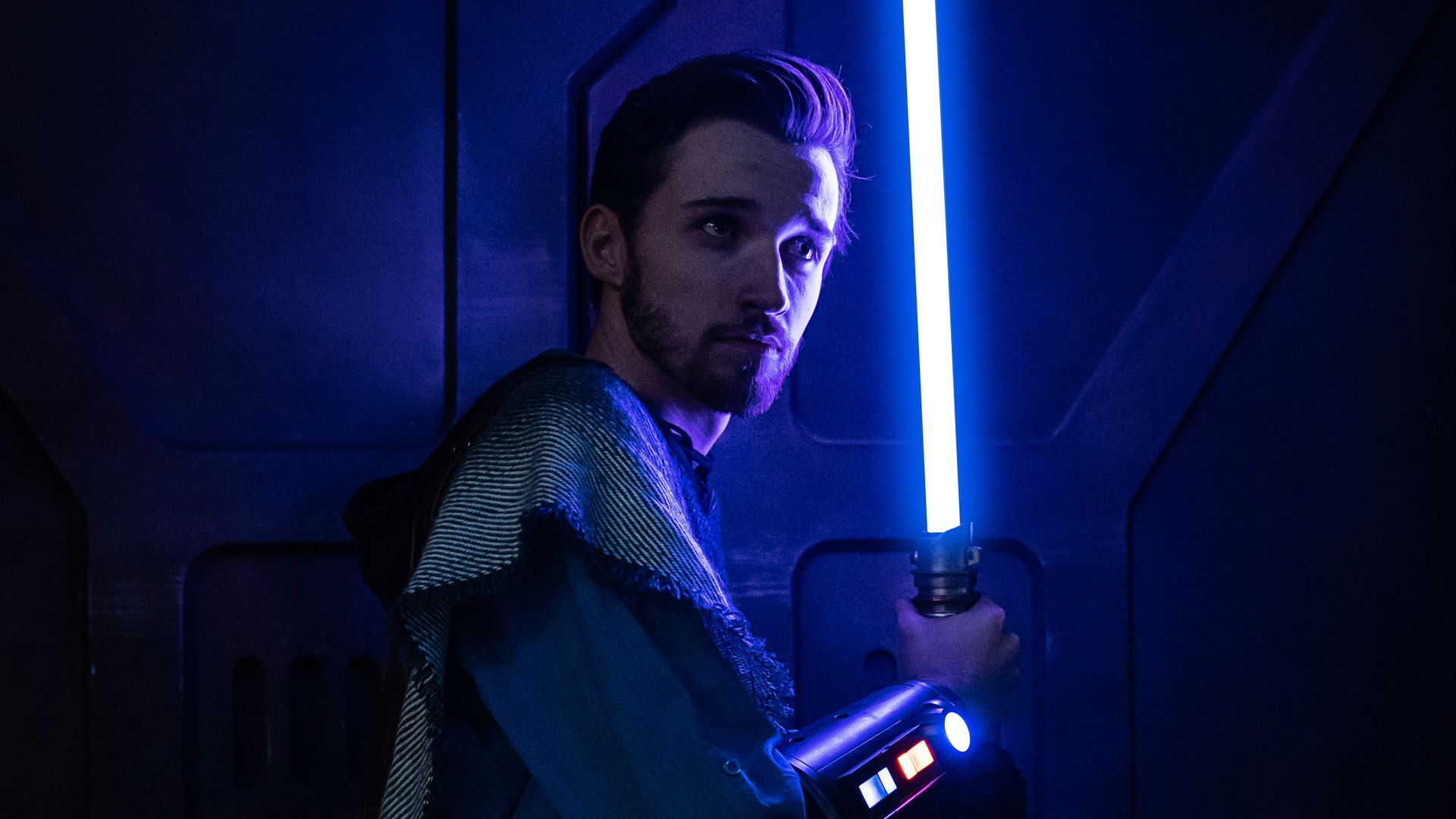 a man holding a light saber in a dark room