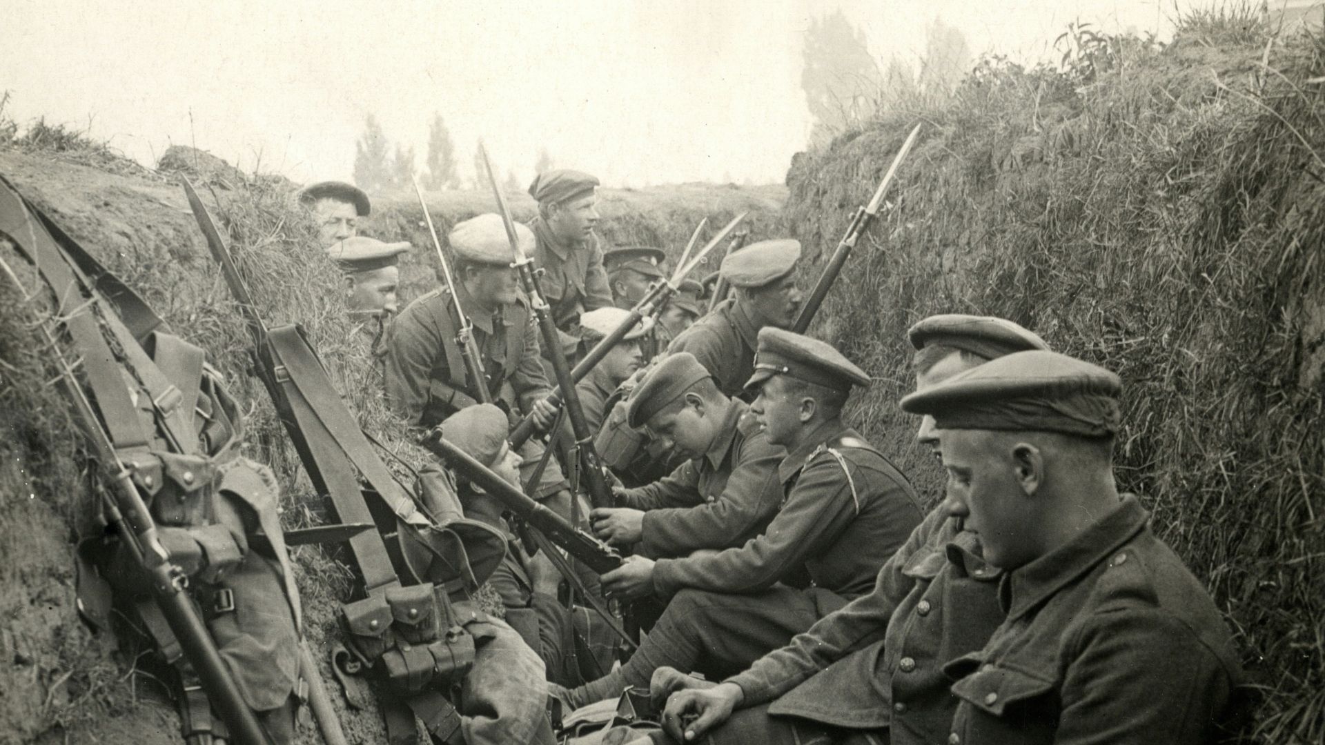 a group of men sitting next to each other in a trench