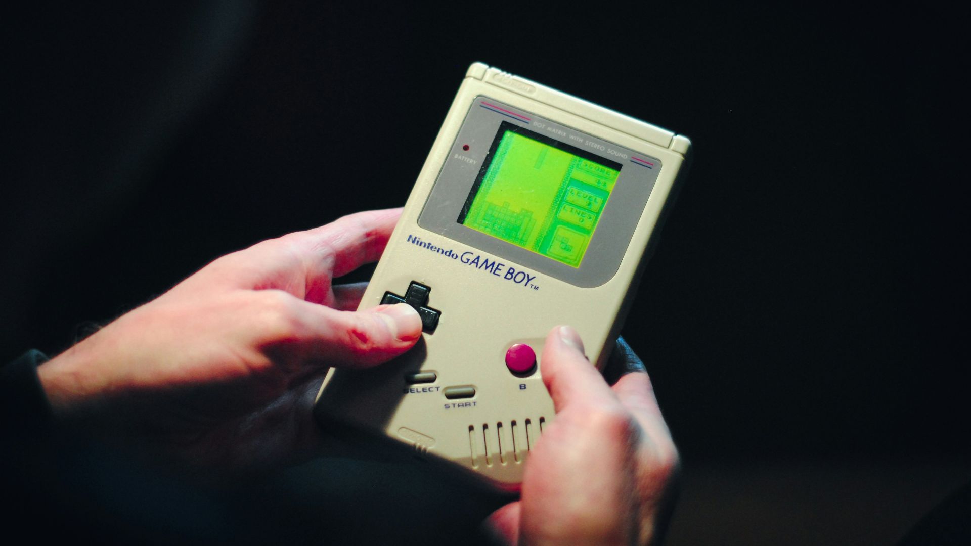person holding gray nintendo game boy