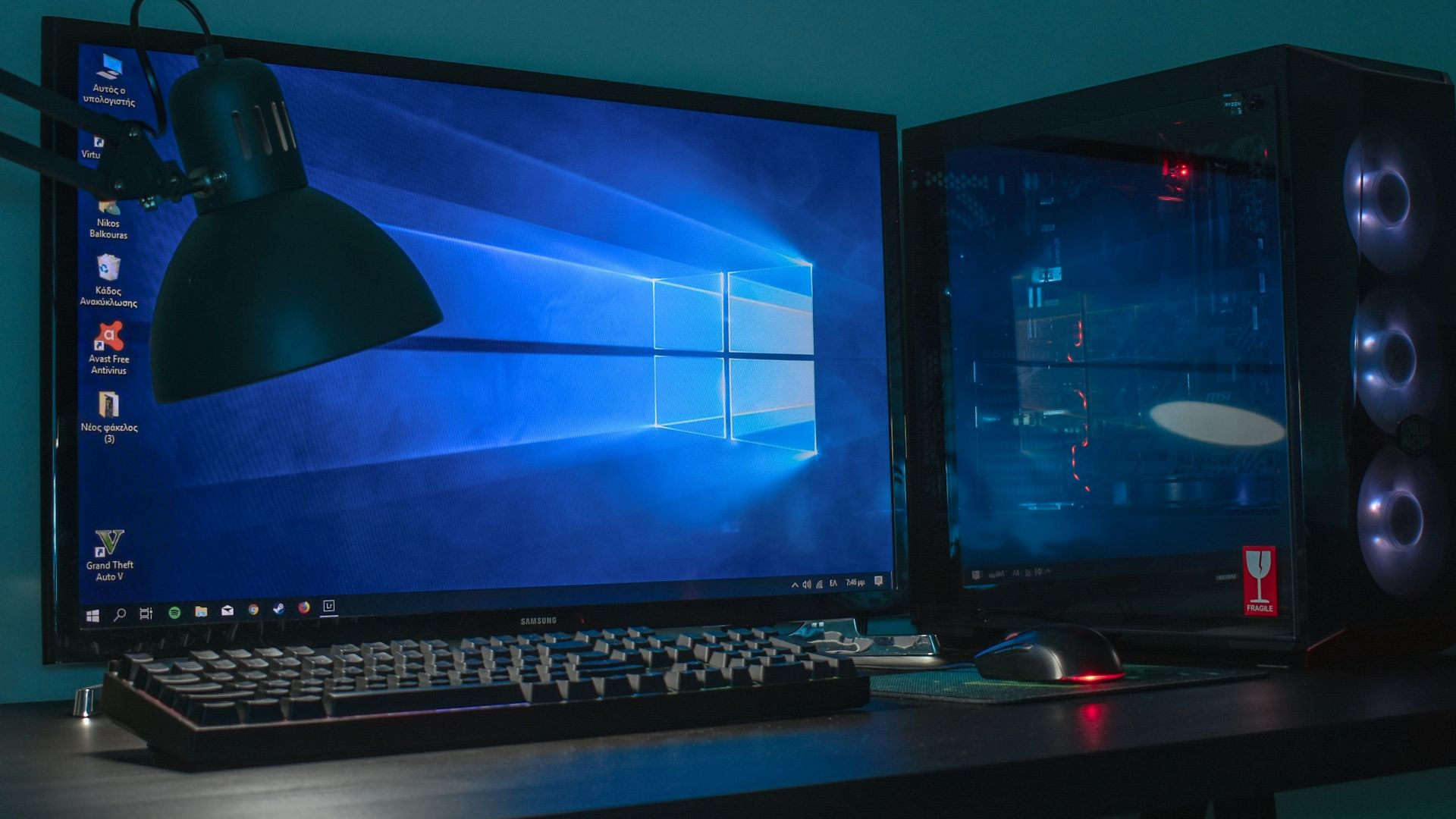 turned on desktop computer set with black and gray leather gaming chair