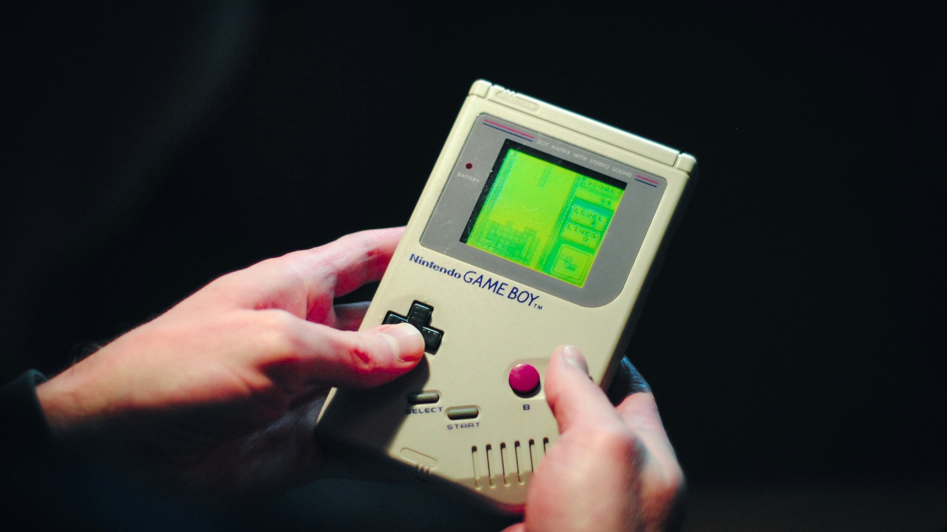 person holding gray nintendo game boy