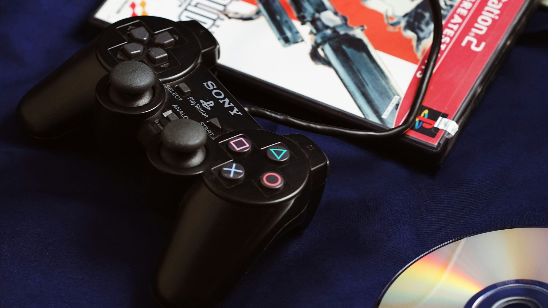 a couple of video game controllers sitting next to a dvd