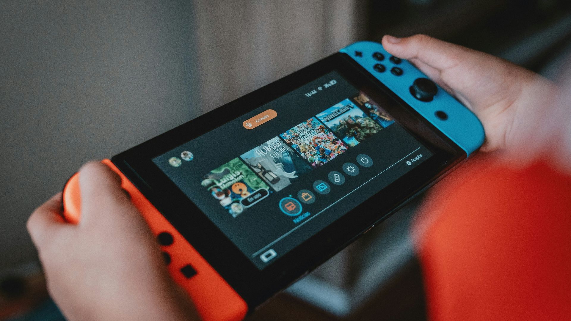 person holding black and orange nintendo switch