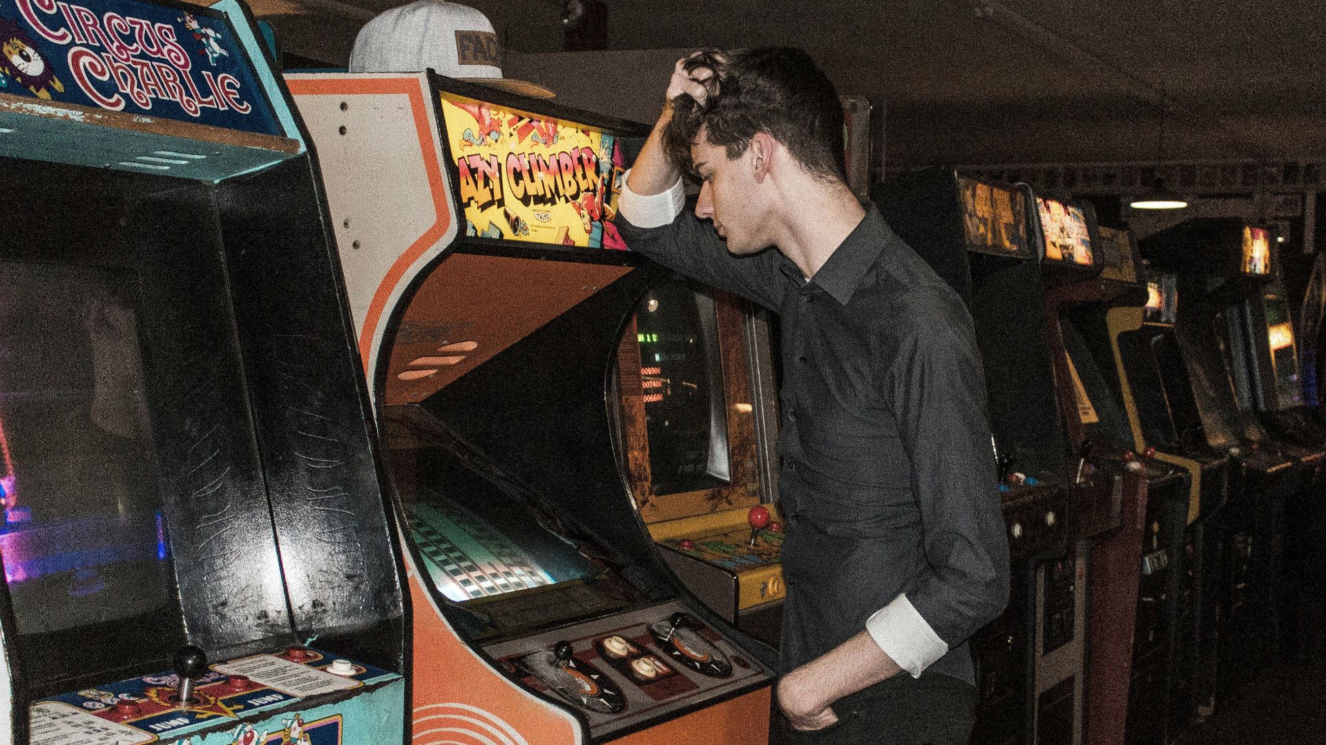 man standing in front of arcade machine