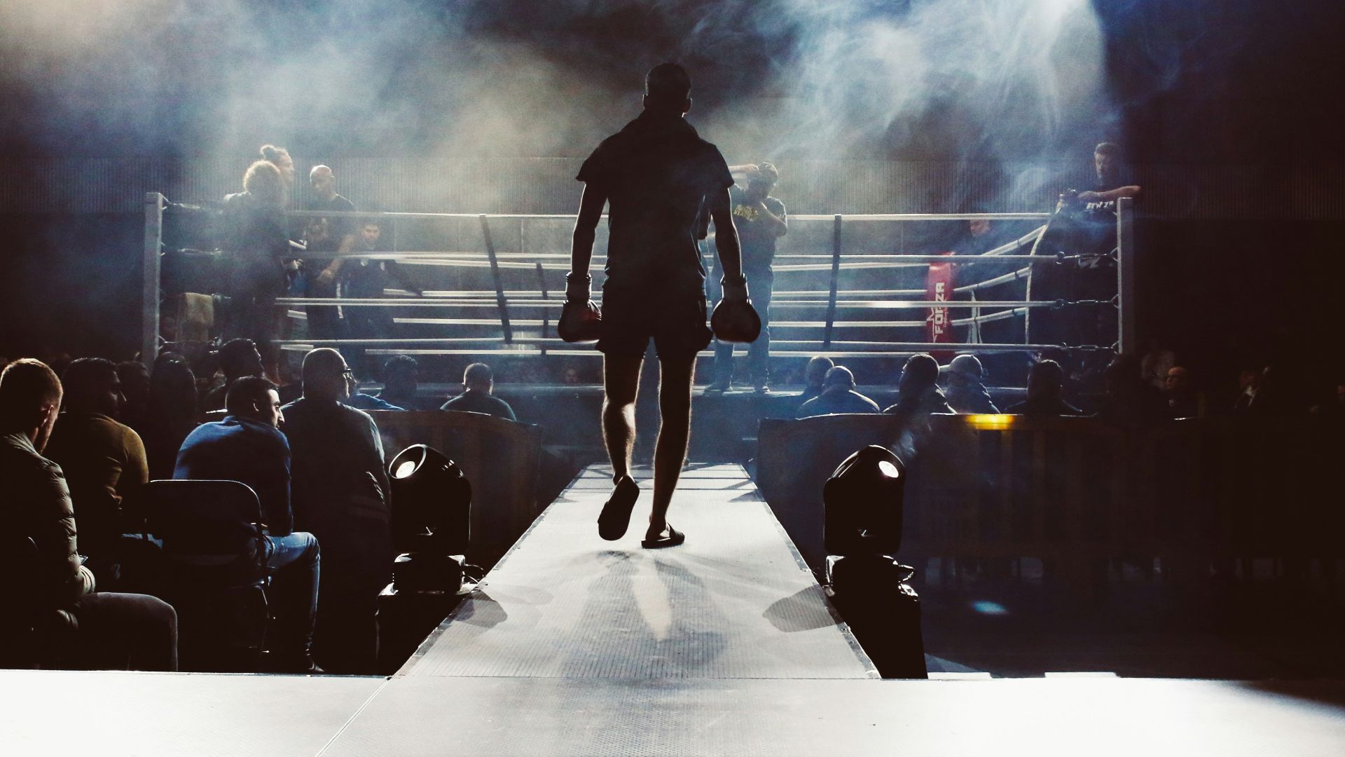 man standing and walking going on boxing ring surrounded with people