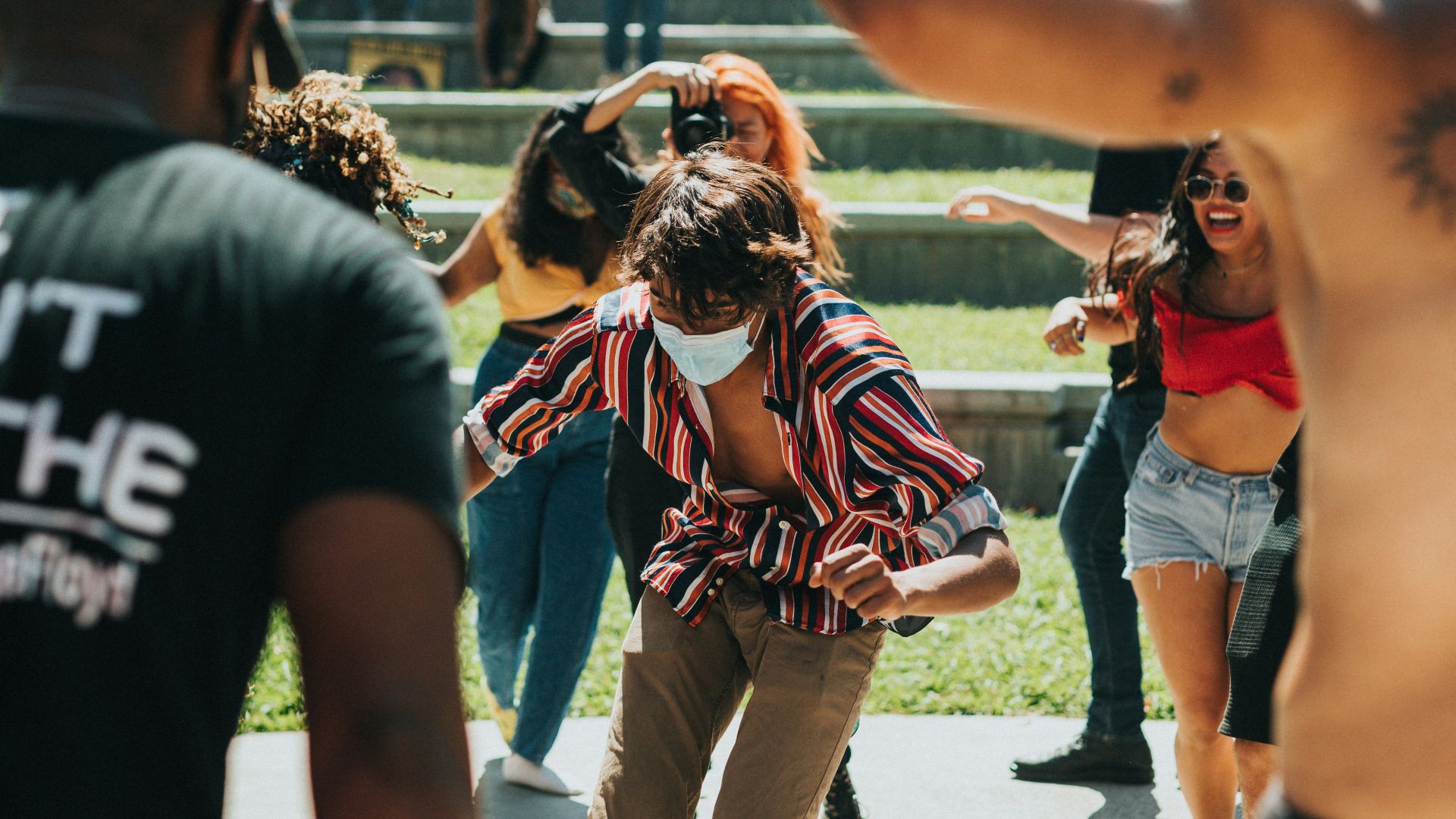 woman in red sports bra and white pants standing on gray concrete floor during daytime