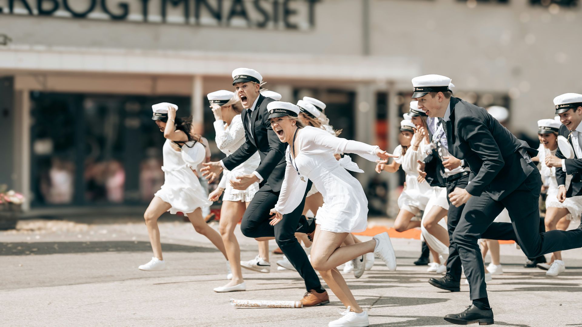 Graduating students cheerfully run from school.