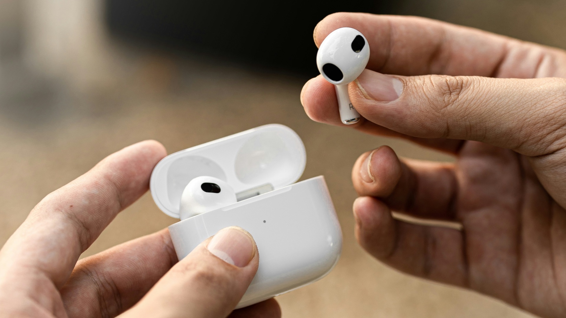 a person holding a pair of airpods in their hands
