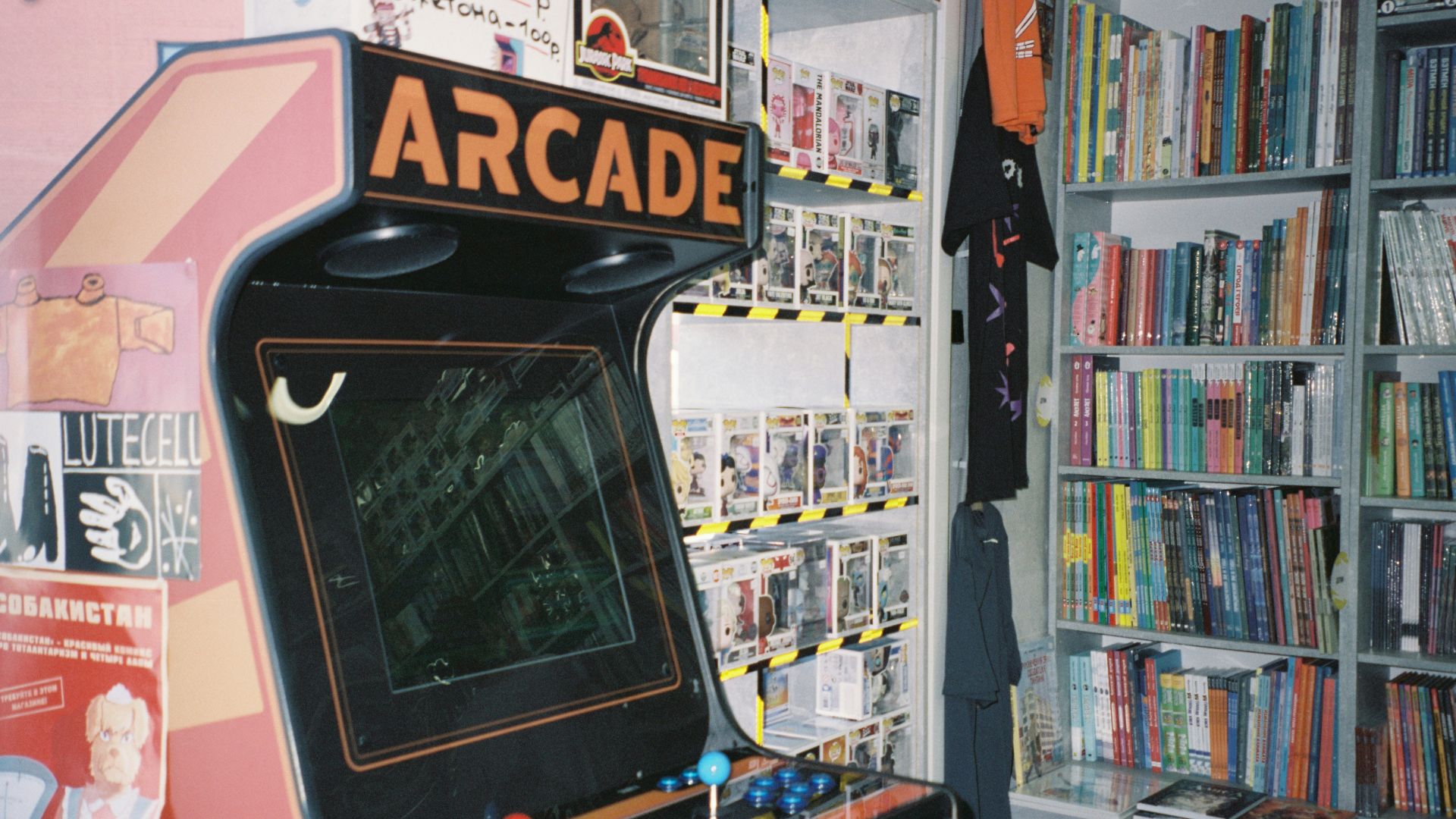 An arcade machine in front of a bookshelf
