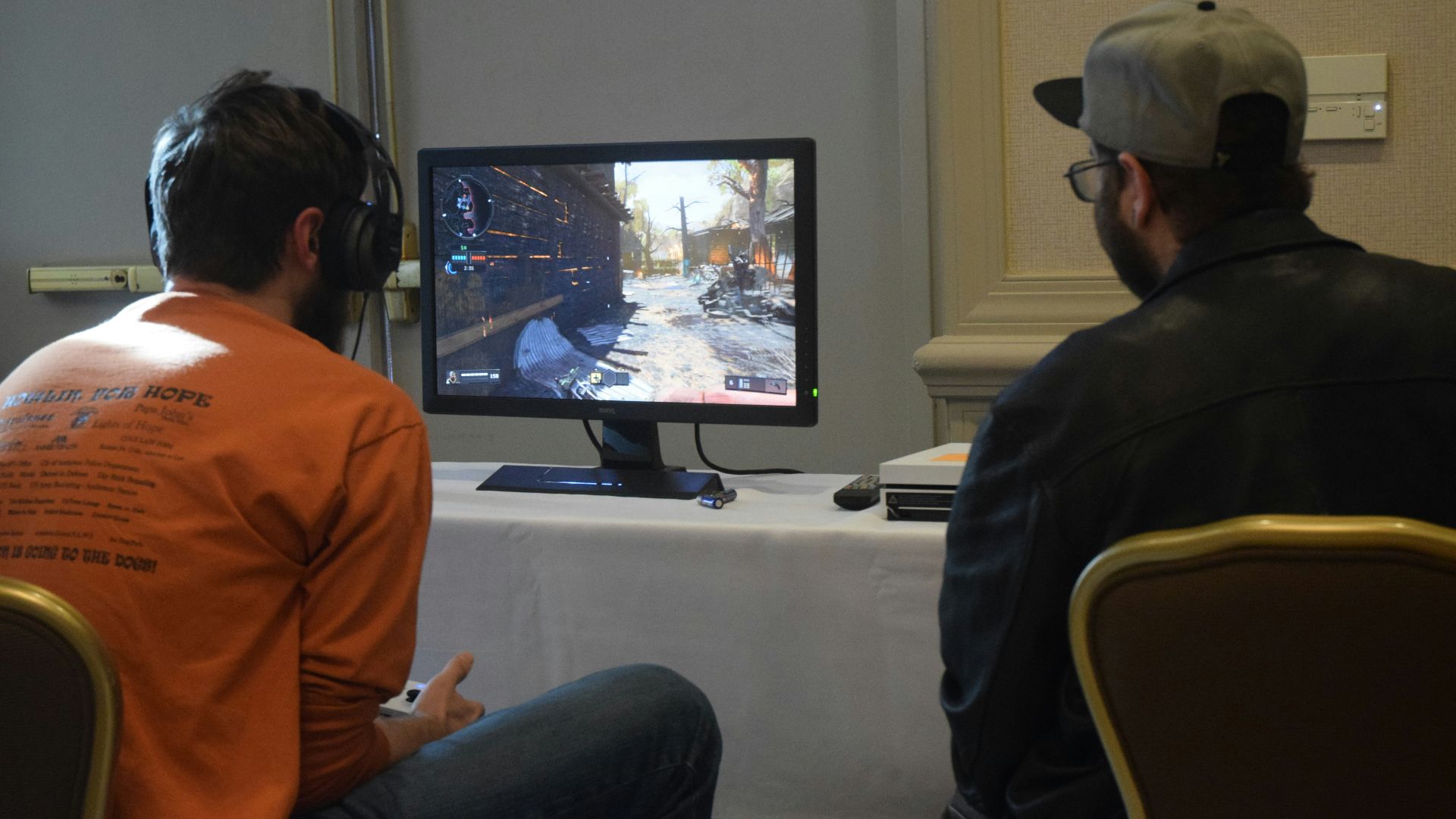 two men playing games facing monitor