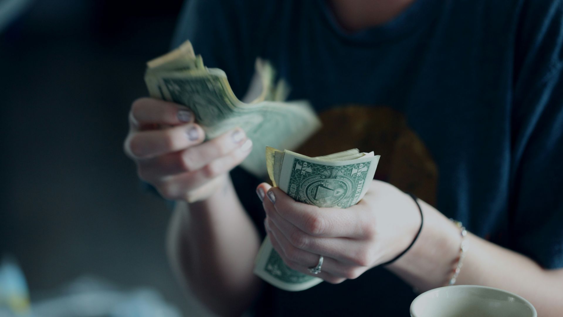 focus photography of person counting dollar banknotes