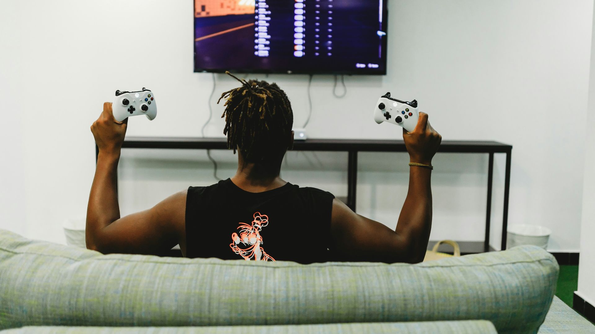 man sitting on couch holding controllers