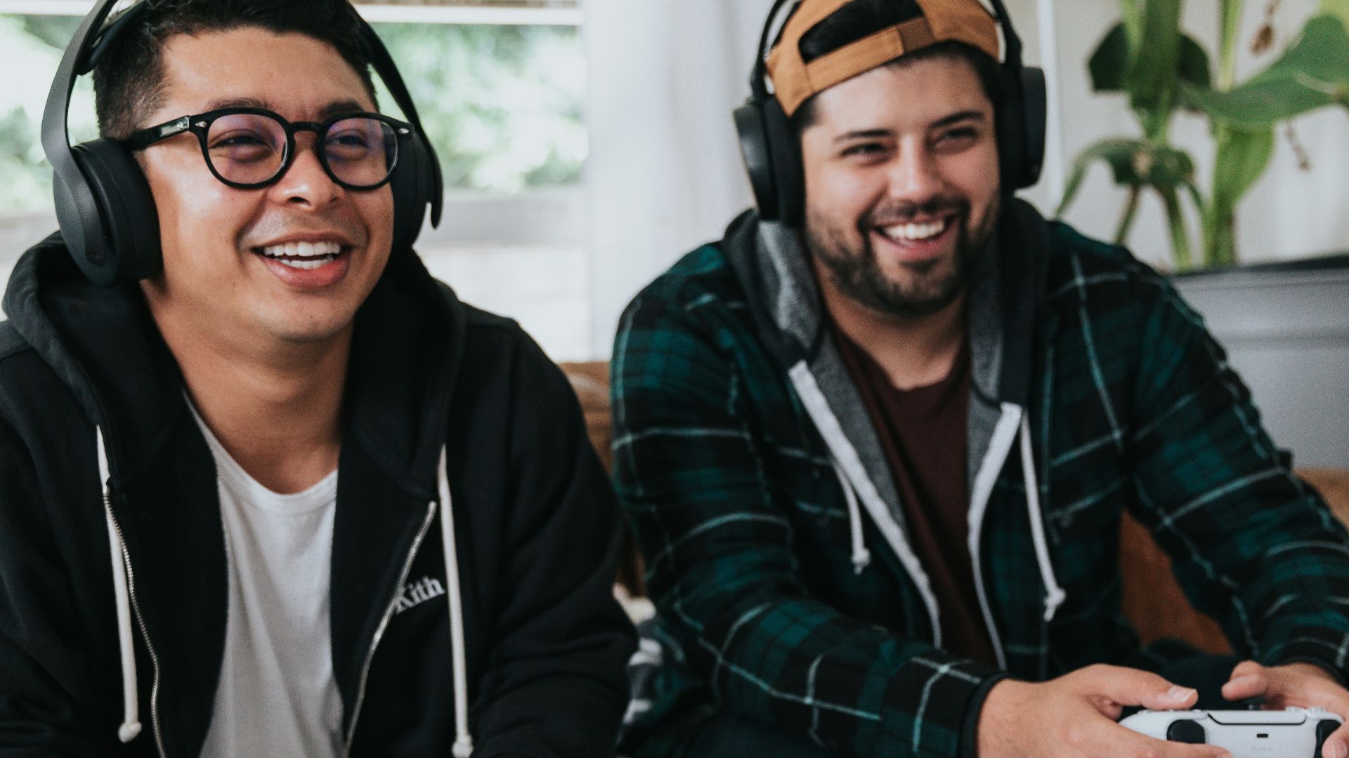 a couple of men sitting at a table with game controllers