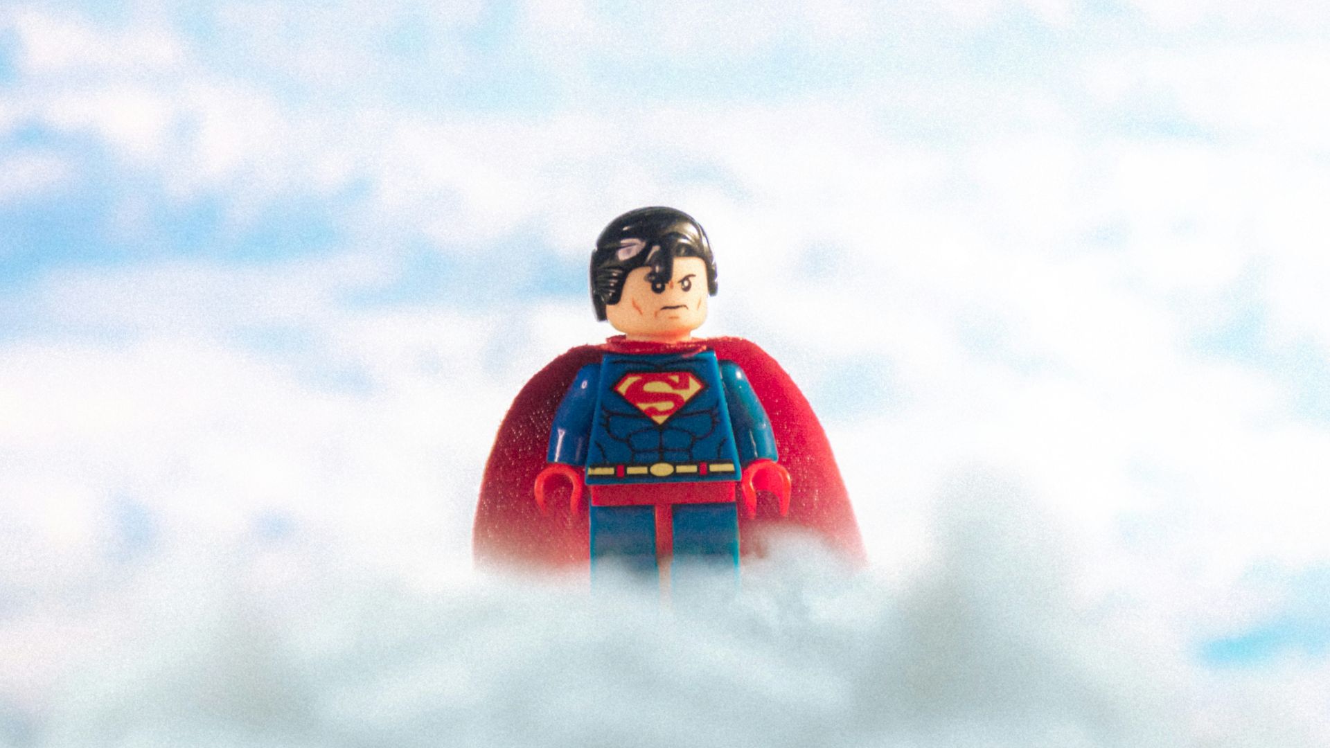 man in red and black jacket standing on snow covered ground during daytime