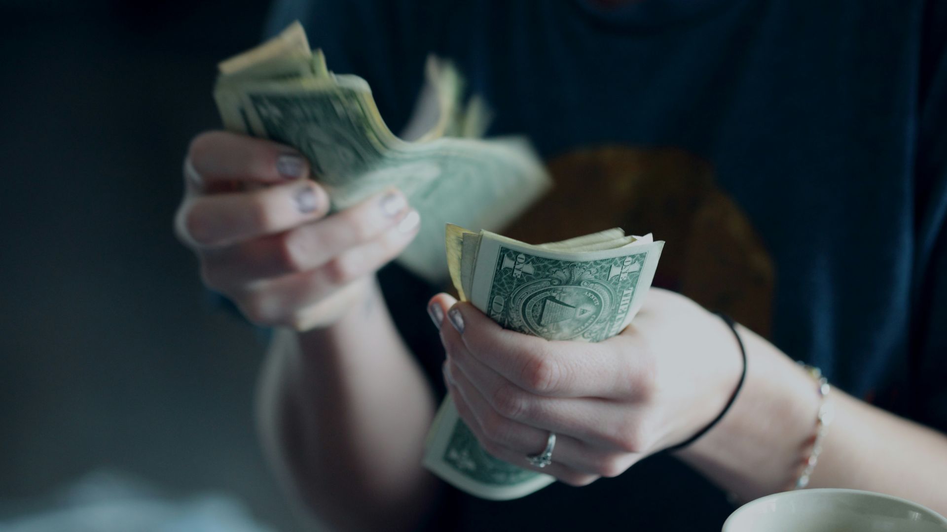 focus photography of person counting dollar banknotes