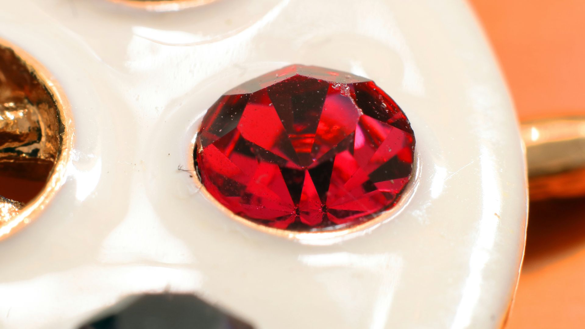 A close up of a white plate with different colored stones on it